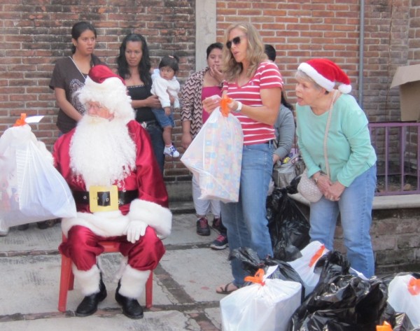 Every family gets a bag of presents. Most wait to open them at home.